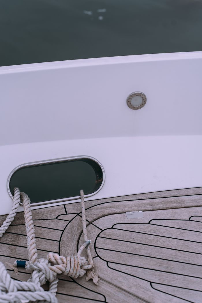 A close-up view of a boat deck with neatly coiled rope, showcasing a minimalist and nautical theme.
